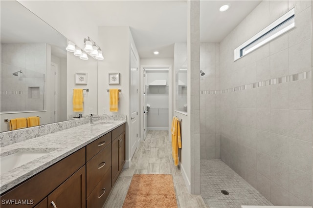 bathroom with vanity, hardwood / wood-style floors, and a tile shower