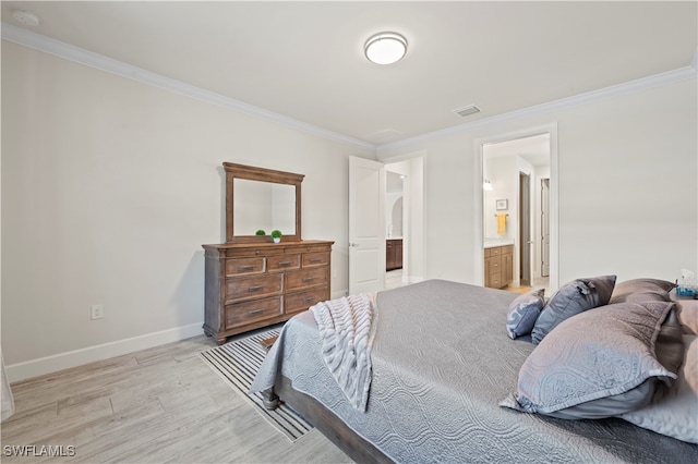 bedroom with light hardwood / wood-style flooring, ornamental molding, and ensuite bathroom