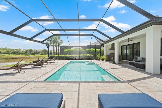 view of swimming pool with outdoor lounge area, a lanai, ceiling fan, and a patio area