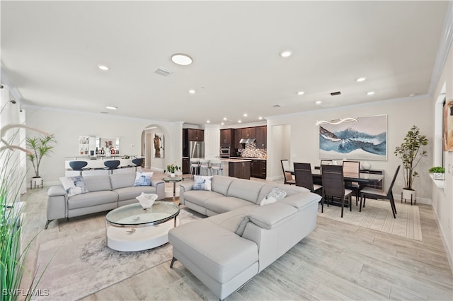 living room with crown molding and light wood-type flooring