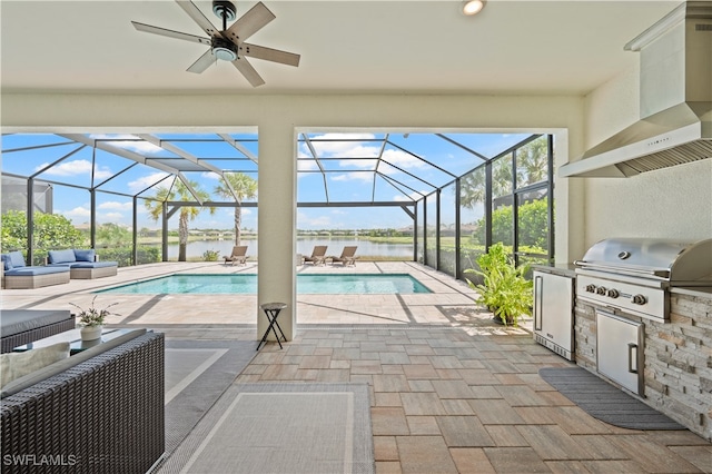 view of pool with glass enclosure, a grill, exterior kitchen, and a patio