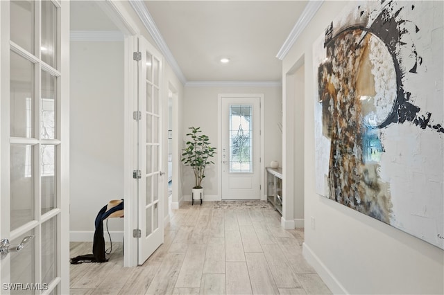 foyer entrance featuring crown molding, french doors, and light hardwood / wood-style floors