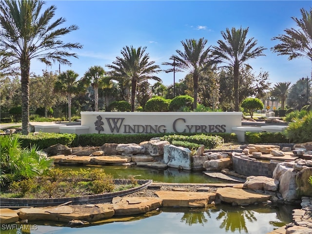 community / neighborhood sign featuring a garden pond