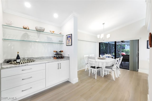 kitchen with open shelves, white cabinets, light stone counters, crown molding, and pendant lighting