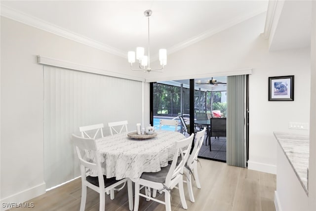 dining space with light wood finished floors, ornamental molding, a notable chandelier, and baseboards