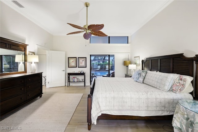 bedroom with visible vents, a high ceiling, ornamental molding, ceiling fan, and light wood-type flooring