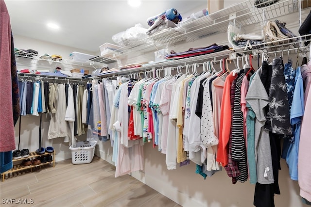 walk in closet with wood finished floors