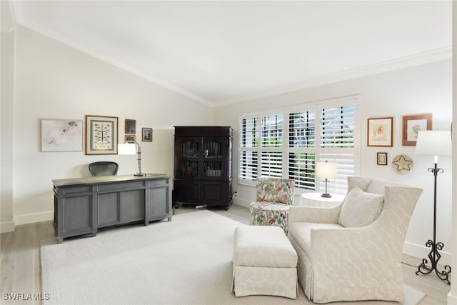 sitting room with light wood finished floors, baseboards, ornamental molding, and vaulted ceiling