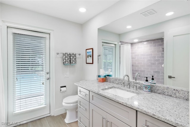 bathroom with recessed lighting, visible vents, toilet, vanity, and wood finished floors