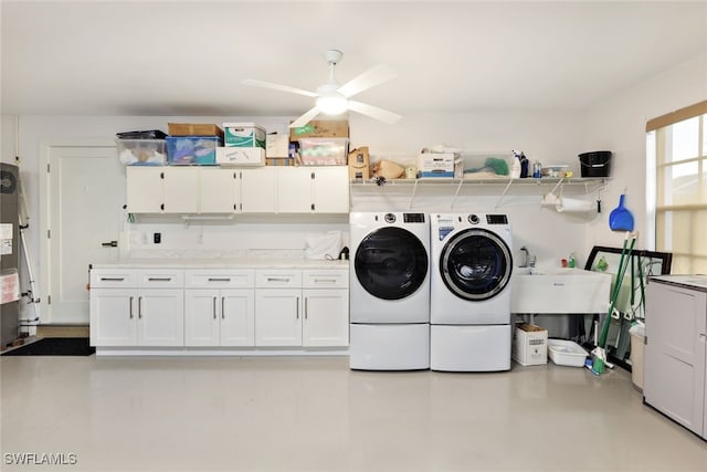 laundry area with cabinet space, a ceiling fan, washer and dryer, water heater, and a sink