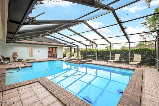 outdoor pool with a lanai, a patio area, and an in ground hot tub