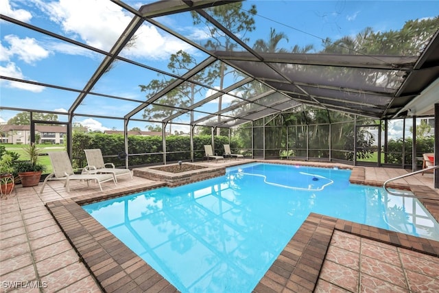 outdoor pool with glass enclosure and a patio area