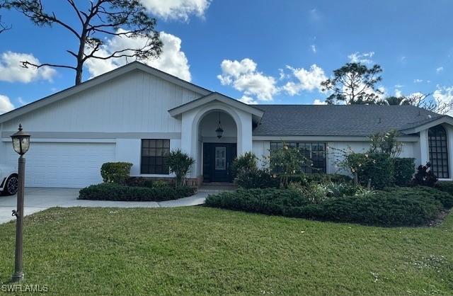 ranch-style house with a garage and a front lawn