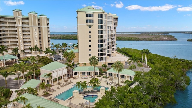 view of building exterior with a community pool and a water view