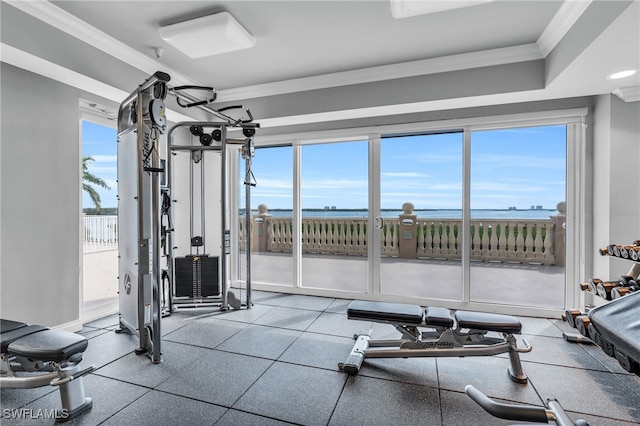 workout area with crown molding and a water view