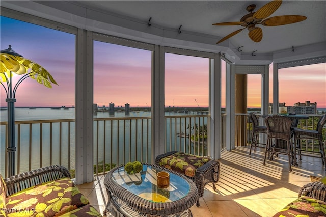 sunroom with a water view, plenty of natural light, and ceiling fan