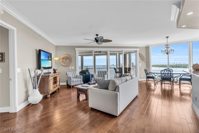 living room featuring dark wood-type flooring, a water view, ornamental molding, and a wealth of natural light