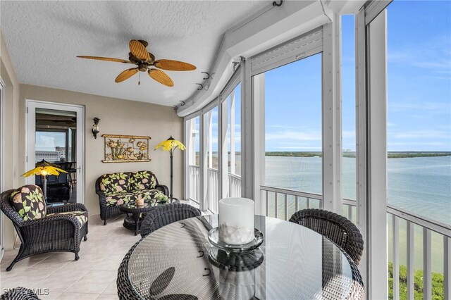 sunroom / solarium with a water view and ceiling fan