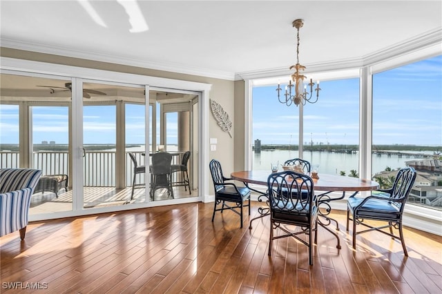 sunroom featuring a notable chandelier, a wealth of natural light, and a water view