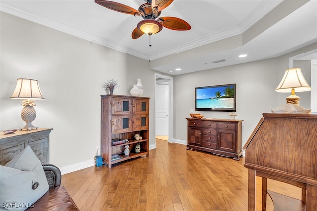 living room with ornamental molding, ceiling fan, and light hardwood / wood-style floors