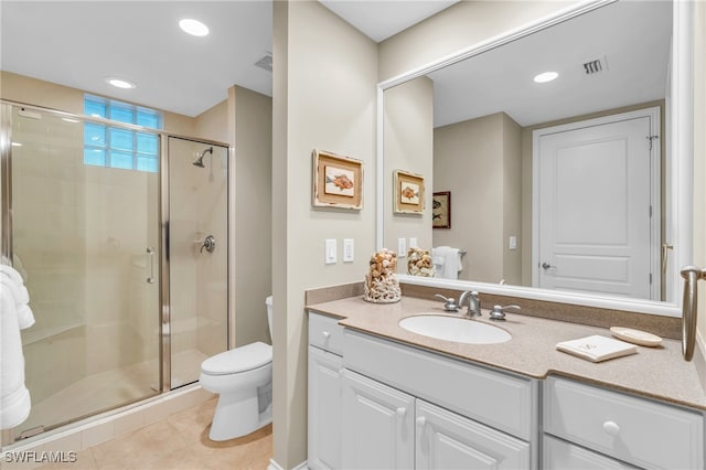 bathroom with vanity, tile patterned floors, a shower with door, and toilet