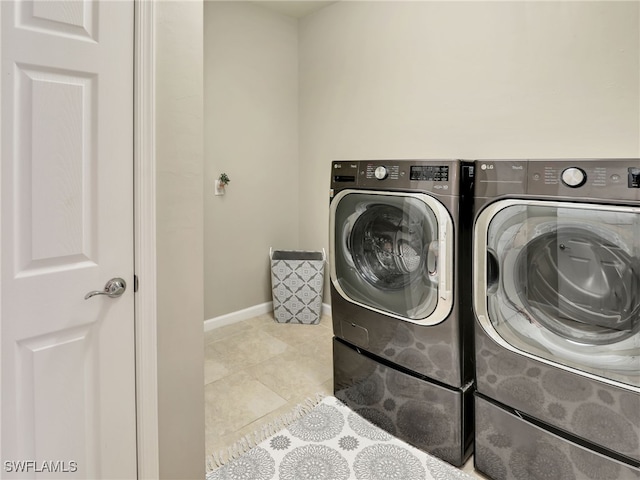 laundry room featuring separate washer and dryer and light tile patterned flooring