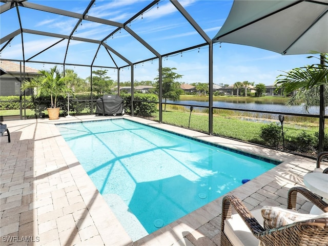 view of swimming pool with a patio, glass enclosure, and a water view