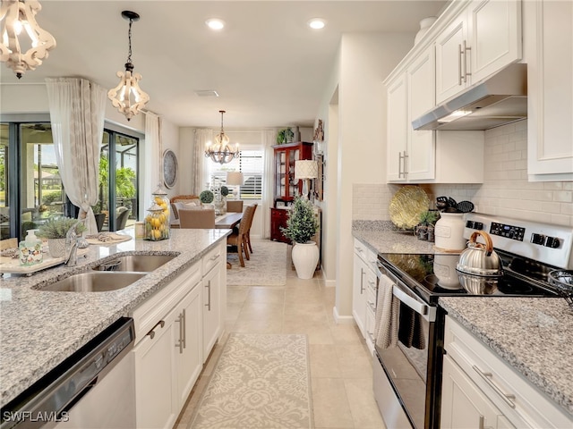 kitchen with light tile patterned flooring, light stone countertops, stainless steel appliances, and white cabinets