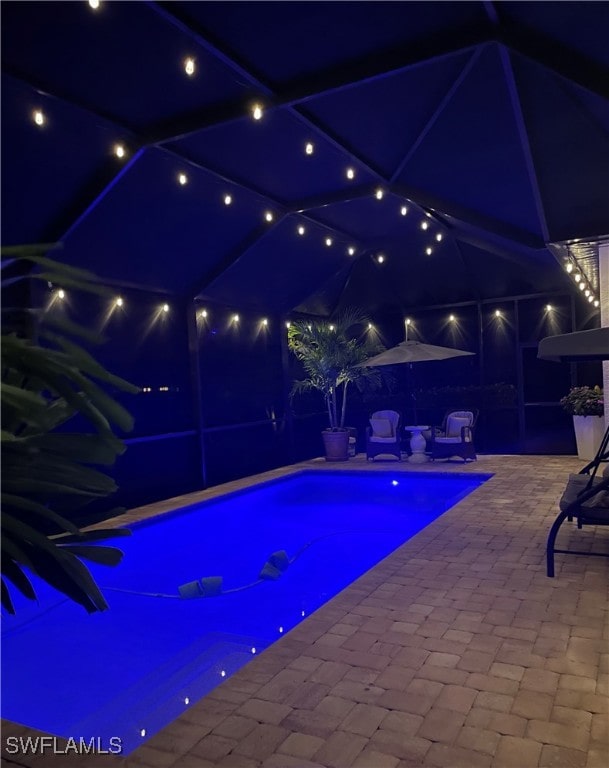 pool at twilight featuring a patio area