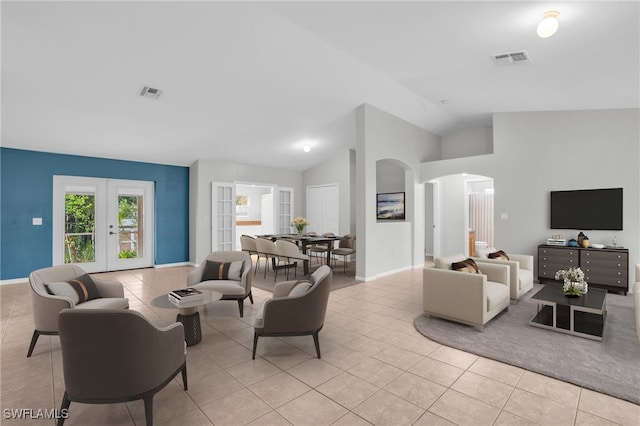 tiled living room featuring vaulted ceiling and french doors