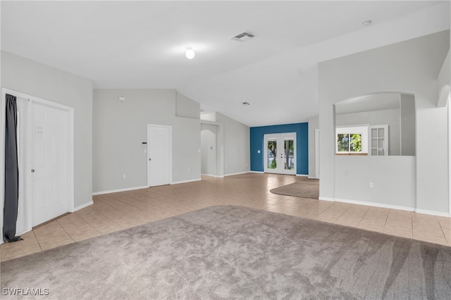 unfurnished living room featuring vaulted ceiling and light carpet