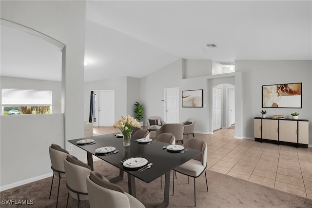 dining area with lofted ceiling and light tile patterned floors