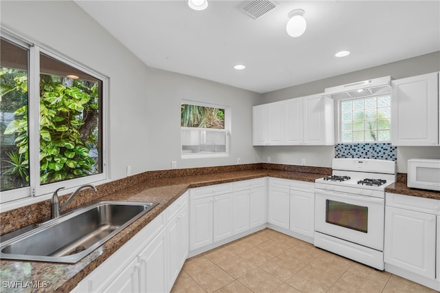 kitchen with sink, white appliances, and white cabinetry