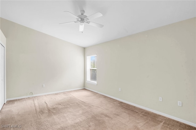 carpeted spare room with ceiling fan