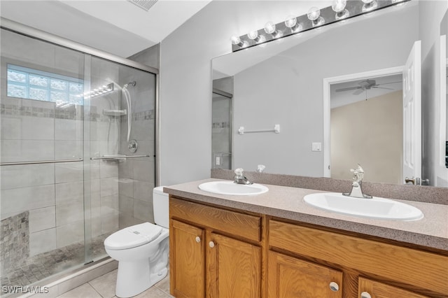 bathroom featuring a shower with door, vanity, toilet, tile patterned floors, and ceiling fan