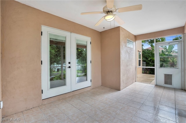 spare room with a wealth of natural light, ceiling fan, and french doors