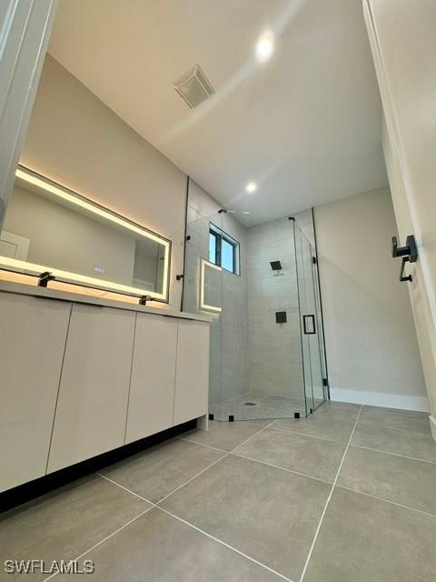 3706 E 19th St, Lehigh Acres, FL 33972 - full bathroom with visible vents, a shower stall, baseboards, tile patterned floors, and vanity