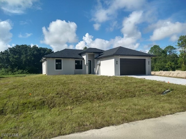 prairie-style home featuring a garage and a front lawn