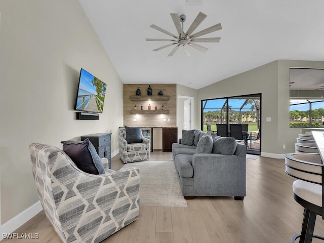 living room featuring ceiling fan, lofted ceiling, and light hardwood / wood-style flooring