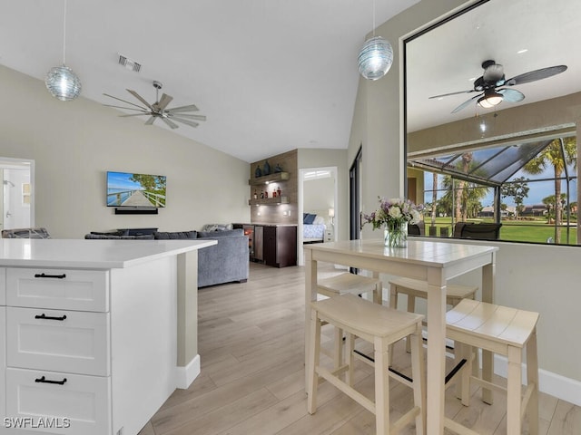 dining space featuring ceiling fan, light hardwood / wood-style flooring, and lofted ceiling