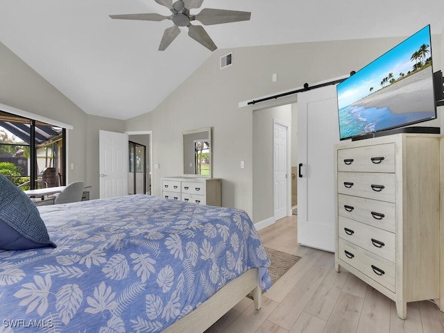 bedroom featuring lofted ceiling, access to outside, ceiling fan, a barn door, and light wood-type flooring