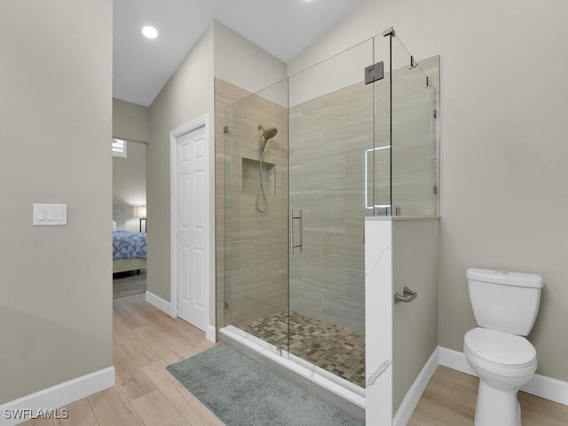 bathroom featuring walk in shower, toilet, and hardwood / wood-style flooring