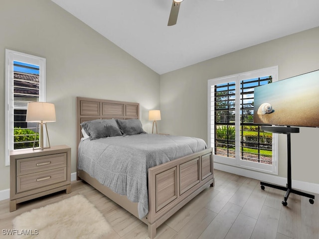 bedroom featuring light wood-type flooring, vaulted ceiling, multiple windows, and ceiling fan