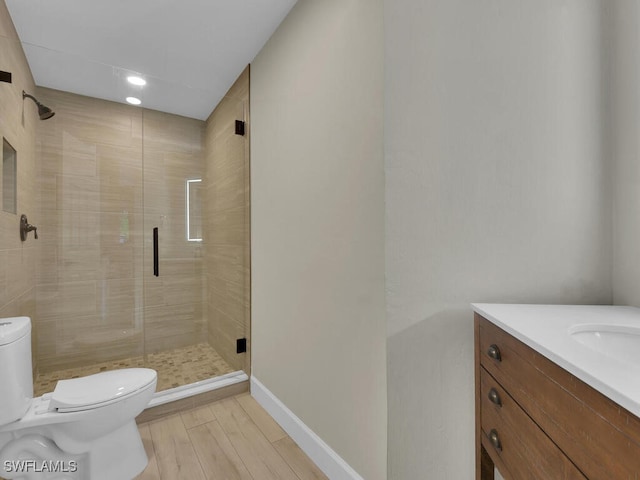 bathroom with vanity, hardwood / wood-style flooring, toilet, and a shower with shower door