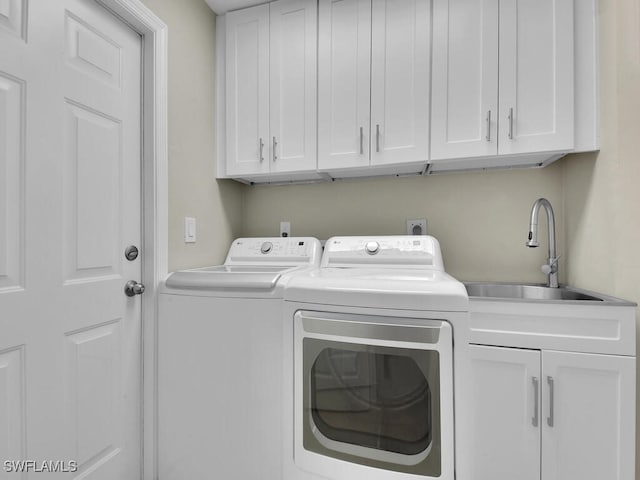 washroom with washer and clothes dryer, cabinets, and sink