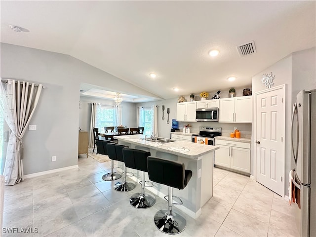 kitchen featuring visible vents, an island with sink, stainless steel appliances, light countertops, and white cabinetry