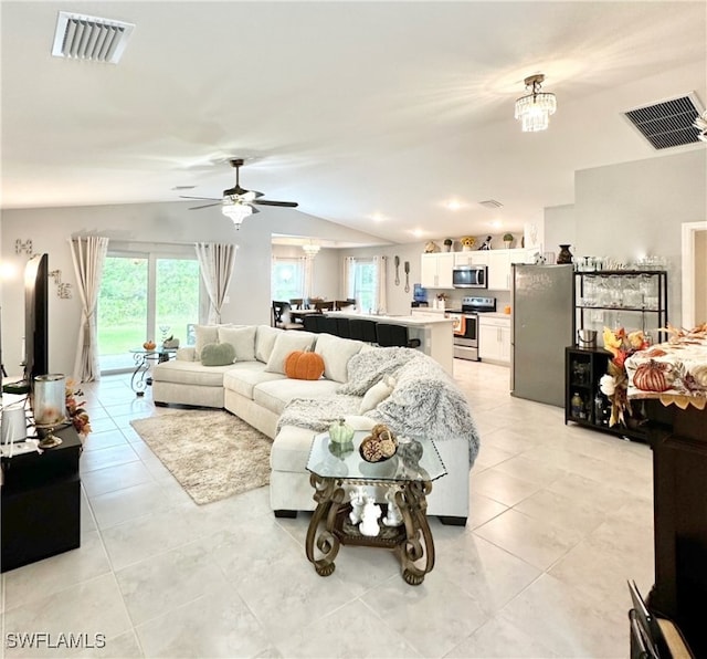 living room featuring a wealth of natural light, lofted ceiling, and visible vents