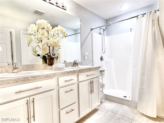 bathroom featuring a stall shower, visible vents, a sink, and double vanity