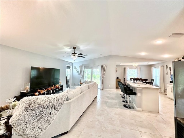 3214 68th St W, Lehigh Acres, FL 33971 - living area featuring light tile patterned flooring, vaulted ceiling, a ceiling fan, and baseboards