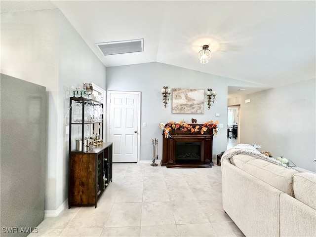 living room featuring vaulted ceiling, visible vents, a fireplace, and baseboards